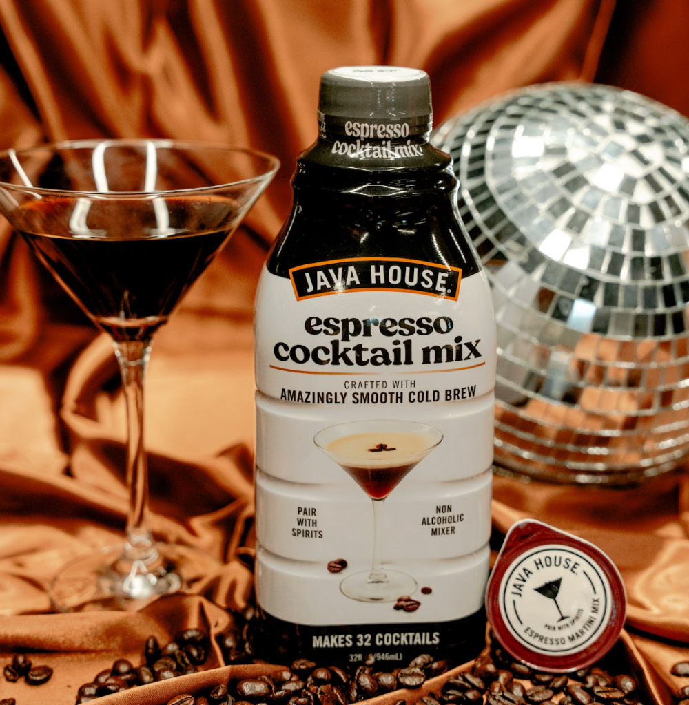 Bottle of Java House espresso cocktail mix next to an espresso cocktail with coffee beans and disco ball in the background